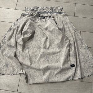 Button shirt with plant and flowers around it